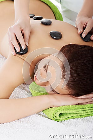 Girl on a stone therapy, hot stone massage Stock Photo