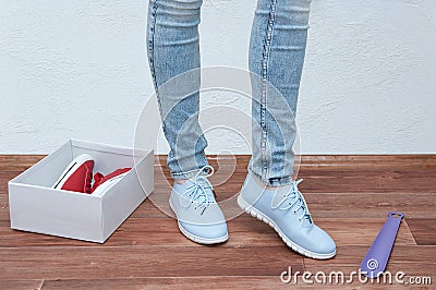 Girl in the store trying on a pair of blue sneakers. Close-up Stock Photo