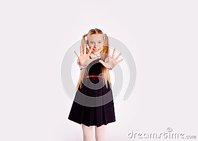 Schoolgirl smiles and stretches out her hands forward with fingers spread Stock Photo