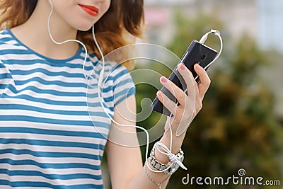 Girl in striped t-shirt is listening to music Stock Photo