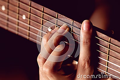 Girl strumming the strings of a guitar. Stock Photo