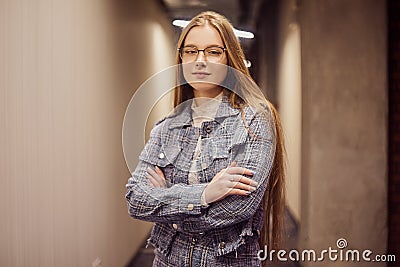 Girl student stands in the corridor of the university / university dormitory. The blonde is looking at the camera. A student with Stock Photo