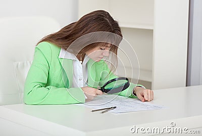 Girl studies drawings by means of magnifier Stock Photo