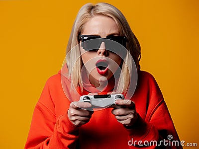 Girl in sunglasses keen plays with a joystick Stock Photo