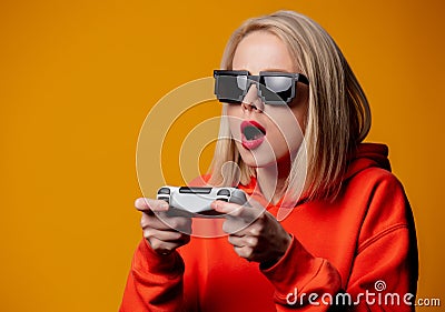 Girl in sunglasses keen plays with a joystick Stock Photo