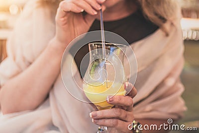 Girl on a sunny day in a cafe drinking a refreshing orange juice through a straw Stock Photo