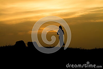 Girl on Sunset rock - Silhouette Stock Photo