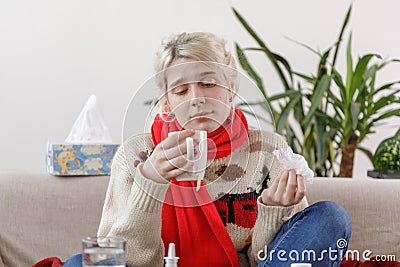 The girl in the sweater is sick and holds a mug with a hot drink. Colds and flu. The patient caught a cold, feeling sick. Stock Photo