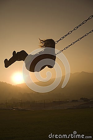 Girl on Swing at sunset Stock Photo