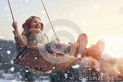 Girl on swing in sunset winter Stock Photo