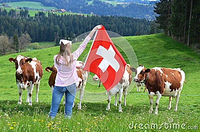 Girl with the Swiss flag against cows Stock Photo