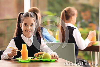 Girl at table with healthy food in school canteen Stock Photo