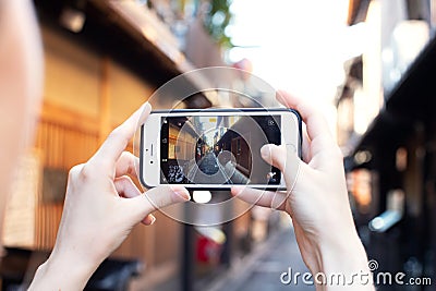 Girl take picture of quiet little street of Kyoto near Gion district with Iphone, instagram blogger concept, Japan Editorial Stock Photo