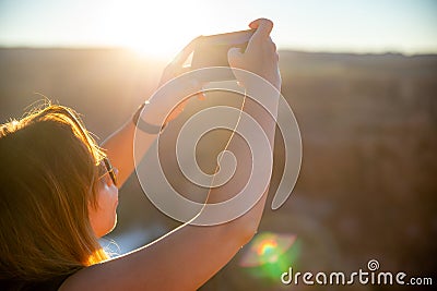 The girl takes a photo at the Horseshoe Bend tourist attraction in Arizona Stock Photo