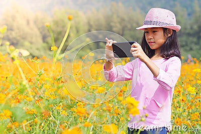 Girl taking photo mobile phones in flowers field Stock Photo