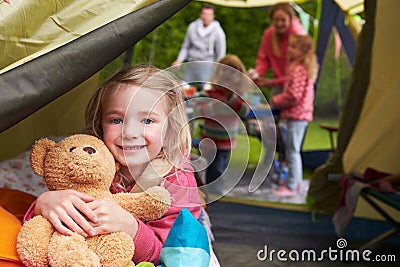 Girl With Teddy Bear Enjoying Camping Holiday On Campsite Stock Photo