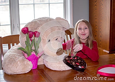 Girl and teddy bear share valentines day gifts Stock Photo