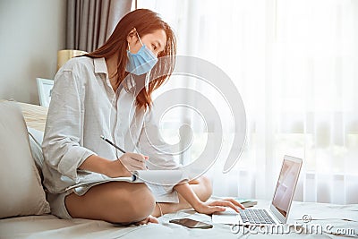 Girl teen education or working at home during covid self quarantine, ware face mask learning online Stock Photo