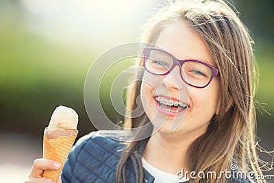 Girl. Teen. Pre teen. Girl with ice cream. Girl with glasses. Girl with teeth braces. Stock Photo