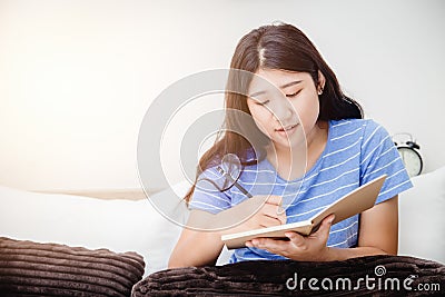 Girl teen taking short note writing to do list at bed when her wakeup in the morning Stock Photo