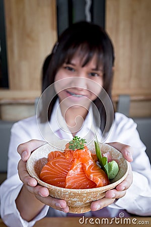 A girl teenage shows a salmon don in a Japanese restaurant Stock Photo