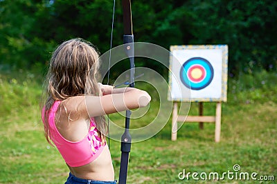 Girl teenager with bow nock and aims to target Stock Photo