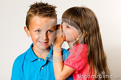Girl telling secret to boy Stock Photo