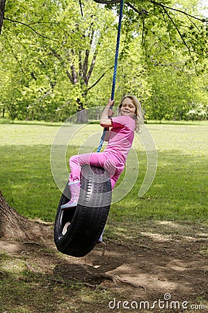 Girl on tire swing Stock Photo