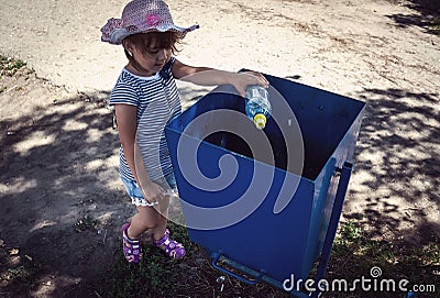 Girl to throw away trash in the trash Stock Photo