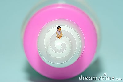 A girl toddler infant drinking a milk of bottle while seat. Isolated on pink background. Stock Photo