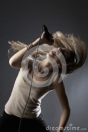 Girl Tossing Hair While Singing In Studio Stock Photo