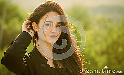 Girl touch long brunette hair on natural landscape Stock Photo