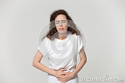 Girl touching stomach suffering from severe ache isolated on grey Stock Photo