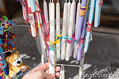 Girl tourist walking in the old souvenir market. Woman hand choosing colorful Easter candles in the Cretan store. Stock Photo