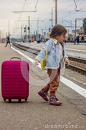 Girl with the travel case on the railway station ready to travel. Stock Photo