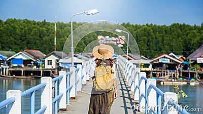 Girl traveler with backpack walking over bridge on the lake Tourism in rural villages Ban Bang Phat - Phangnga. Asian woman travel Stock Photo