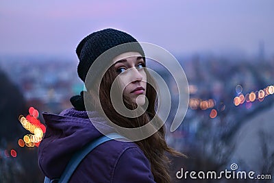 Girl traveler standing in front of winter evening cityscape Stock Photo