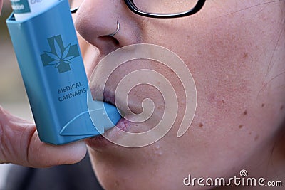 Girl treating asthma with cannabis inhaler Stock Photo