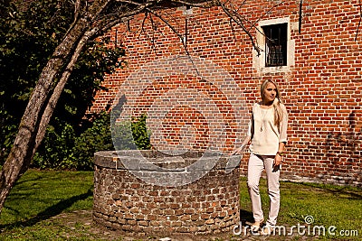 Girl tree brick stone wall well, Groot Begijnhof, Leuven, Belgium Stock Photo