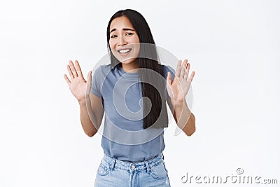 Girl trying jokingly refuse strange offer, step back and laughing awkward, raising hands up in surrender or rejection Stock Photo