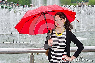 The girl with an umbrella at the fountain Stock Photo