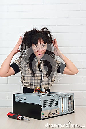 Girl unsuccessfully trying to repair the computer Stock Photo