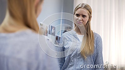 Girl is upset of static dry and damaged hair in winter period, self-doubt age Stock Photo