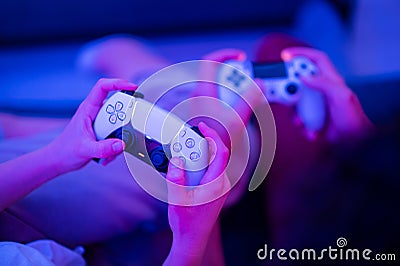 Girl using new Sony Playstation 5 DualSense wireless controller which offers immersive haptic feedback, dynamic adaptive Editorial Stock Photo