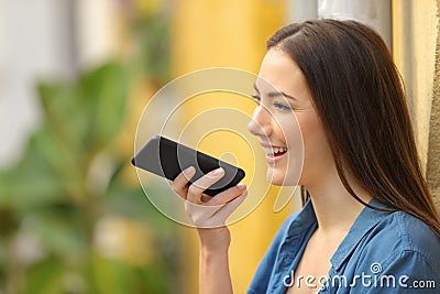 Girl using voice recognition on phone in a colorful street Stock Photo