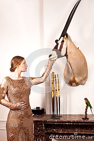 Girl in Vintage dress with stuffed oryx and bird Stock Photo