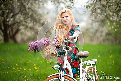 Girl with vintage white bicycle with flowers basket Stock Photo