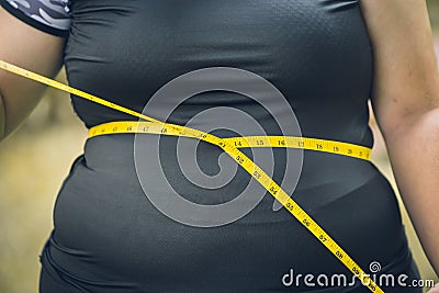 Girl waist belly fat woman with waist tape measure closeup shot Stock Photo