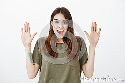 Girl waiting for high five after receiving good news about successful finish of project. Positive happy woman in dark Stock Photo