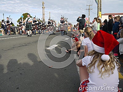 New Zealand: small town Christmas parade girl waiting for Scottish bagpipe band Editorial Stock Photo